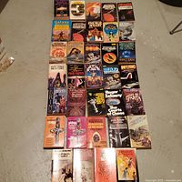 All 34 paperbacks laid out in rows, front covers visible