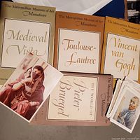 Four Metropolitan Museum of Art Miniatures books with partial view of loose art plates