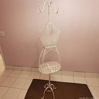 Full view of assembled white wrought iron mannequin coat stand