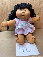 Front view of Cabbage Patch Kids doll seated, full body visible