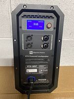 Front view of Electro-Voice ETX-18SP amplifier plate showing LCD screen illuminated