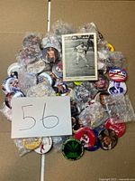 Overall lot showing pile of pinback buttons and signed photo