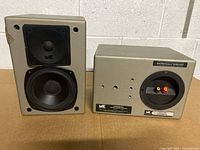 Front and rear view of left speaker showing drivers, cabinet finish, rear label and terminals