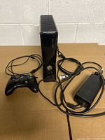 Console upright with controller, power supply and cables visible