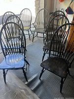 Group of eight black Windsor chairs showing overall quantity and style