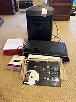All items grouped: shredder, scanner, NETGEAR box, paper ream, trays, CD, cables