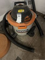 Full view of RIDGID wet/dry vacuum with hose attached and MaxSold sticker visible
