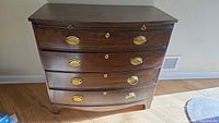 Front view showing four drawers with brass pulls and keyholes