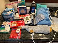All items on countertop showing blood pressure monitor, wound care kit, heating pads, bandages