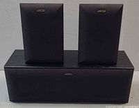 Front view of all three speakers showing size relation and grills with logos