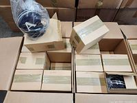 Three cartons containing multiple boxed radios and a few unboxed helmet units visible