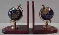 Front view showing both globe bookends on dark cherry wood bases