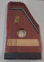 Full view of the chord zither showing body, strings, decal and size