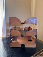 Frontal view showing three stacked wooden trays with metal side supports