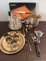 Overall lot view with ice bucket, goblets on tray, shot glasses in caddy, bar tools