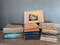 Stack of sealed and loose bedding sheets, showing variety of colours and packaging