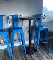 four blue metal stools beside pub tables