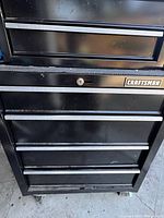 Close-up of lower cabinet front with Craftsman badge and lock