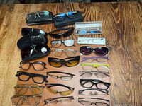 Overhead view showing entire lot of approximately twenty-one eyewear pieces on table