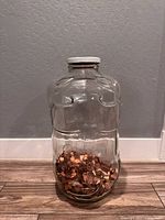 Full view of glass piggy bank jar with pennies