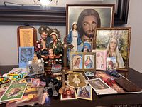 Overview of entire lot showing framed prints, statues, rosaries, prayer cards and accessories