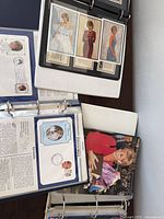 Open binder showing stamp pages with certificates and Princess Diana portraits