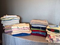 Three stacks of assorted towels on a table