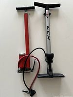 Side-by-side view of both floor bicycle pumps showing full length, barrels, hoses and handles