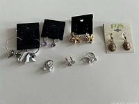All seven pairs of earrings laid out including three on cards and four loose pairs