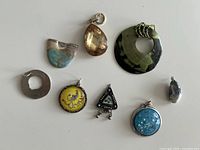 Overview of eight assorted pendants laid out on white surface