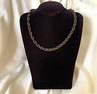 Full view of brass braided chain necklace displayed on bust