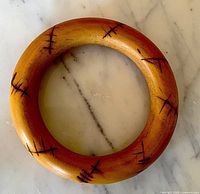 top view of entire wooden bangle showing color and painted accents