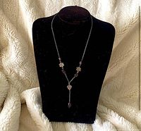 Full view of necklace displayed on bust showing overall design and drop