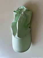 Top view of mint green Lululemon cap with neck flap