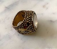 Side view showing beaded texture and magnifying glass lens