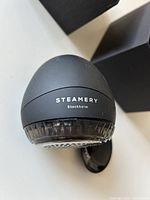 Steamery Pilo fabric shaver front view showing logo and lint reservoir