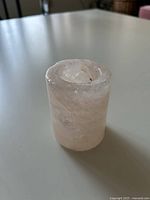 Side view of pink cylindrical candle holder on table