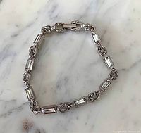 Full view of silver-tone bracelet showing alternating baguette and marquise crystal links