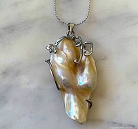 front view of baroque pearl pendant with silver filigree and chain