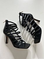 Full side view of both black strappy heels
