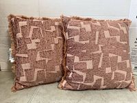 Front view of both pillows showing pattern and fringe