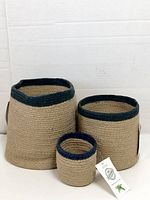 Three Alkaso jute baskets standing side by side with tags visible