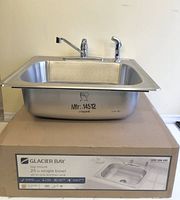 Sink resting on retail box showing faucet and overall form