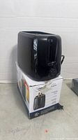 Toaster on top of its retail box, front control knob visible