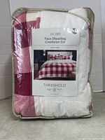 Front of packaged Threshold comforter set showing plaid fabric and label
