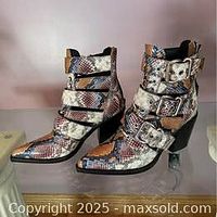 Side view of both ankle boots showing snakeskin pattern, buckle straps, pointed toes, stacked heels