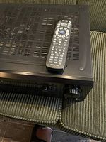 Top view of receiver with remote on top showing vent grills and remote keypad