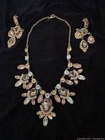 Front view of necklace and earrings showing design and stones