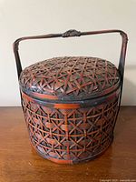 front view of round woven bamboo basket with lid and handle
