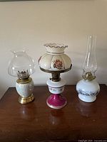 All three vintage hurricane oil lamps on table